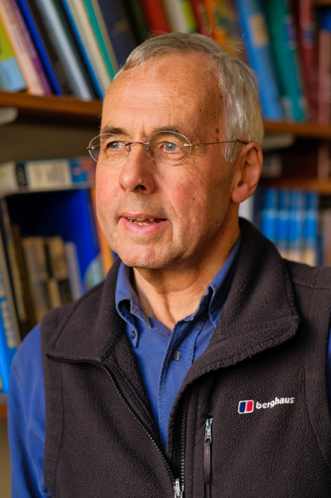 Headshot of Nigel Woodcock who is wearing glasses and a dark, collared shirt.