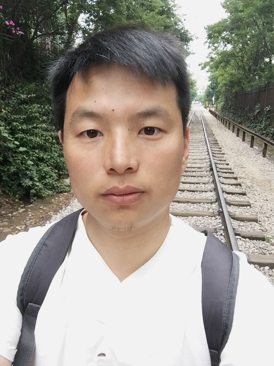 Headshot of Qian Yuan who has dark hair and is wearing a light shirt.